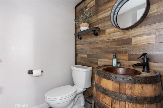 bathroom with wooden walls and toilet