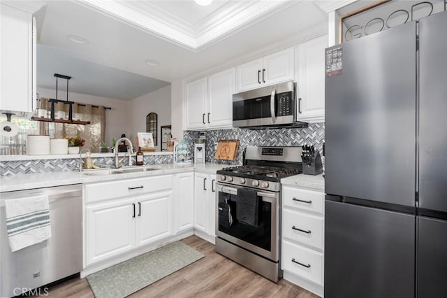 kitchen featuring stainless steel appliances, sink, white cabinets, and backsplash