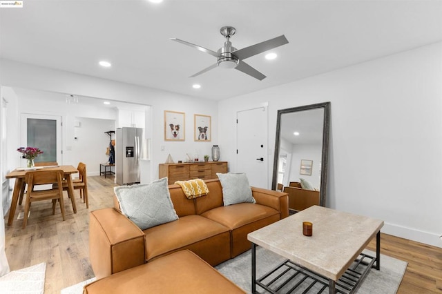 living room with light hardwood / wood-style flooring and ceiling fan