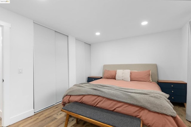 bedroom with light wood-type flooring and a closet