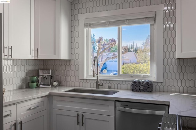 kitchen with white cabinetry, dishwasher, sink, and tasteful backsplash