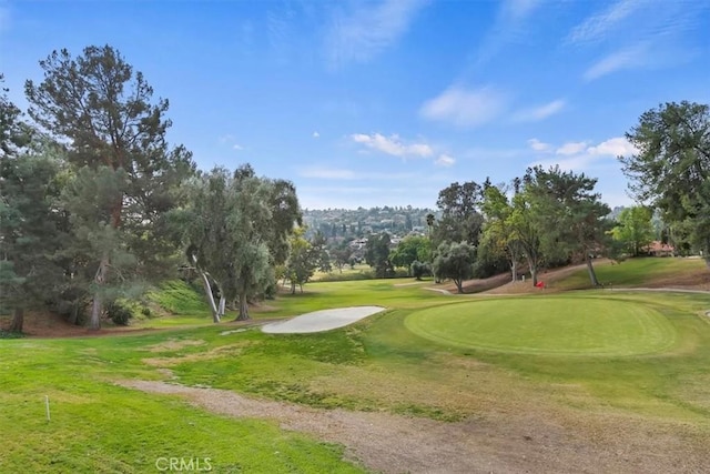 surrounding community featuring golf course view and a lawn