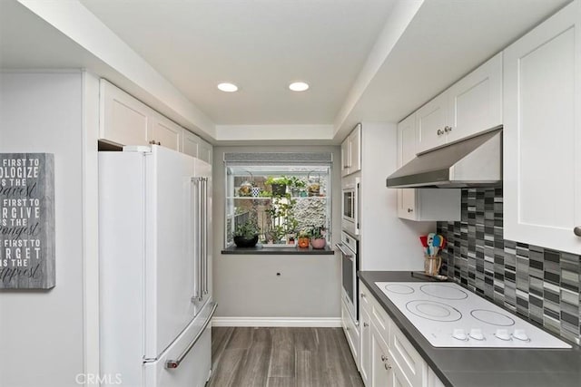 kitchen with dark wood-type flooring, white cabinets, white appliances, and decorative backsplash