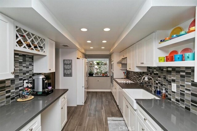 kitchen featuring sink, dark hardwood / wood-style floors, white cabinets, and white fridge