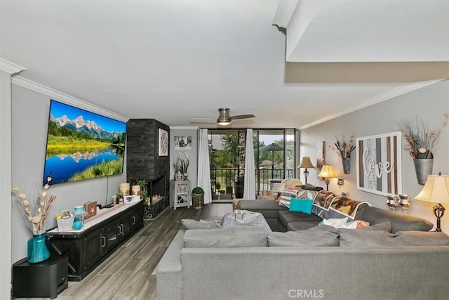 living room featuring dark wood-style floors, floor to ceiling windows, a fireplace, and crown molding