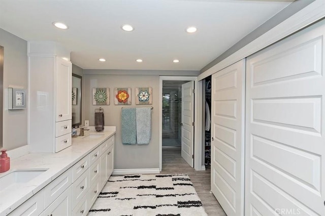 bathroom with vanity, wood-type flooring, and a shower with shower door