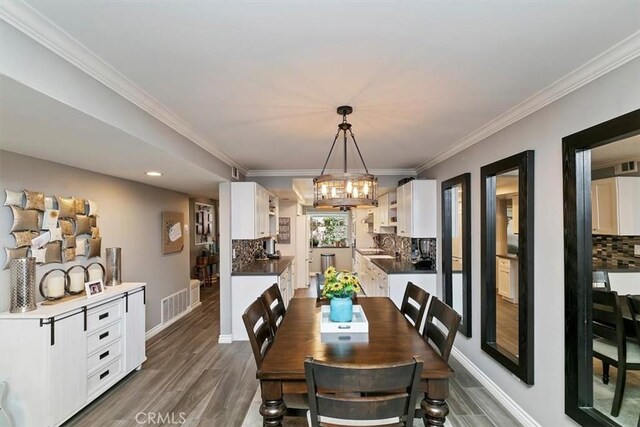 dining room featuring crown molding, dark hardwood / wood-style floors, and a chandelier