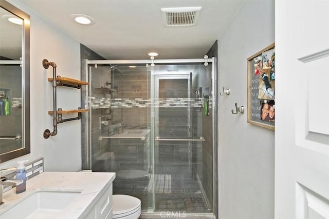 bathroom with vanity, toilet, and an enclosed shower