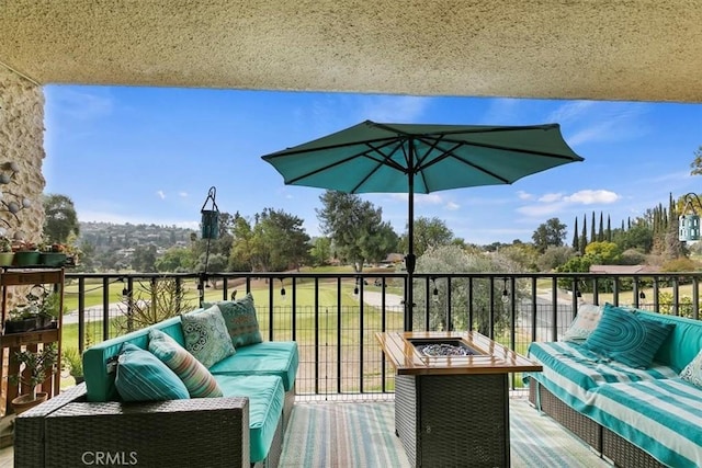 balcony with an outdoor living space with a fire pit