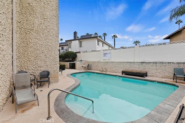 pool with a patio area, a fenced backyard, and a grill