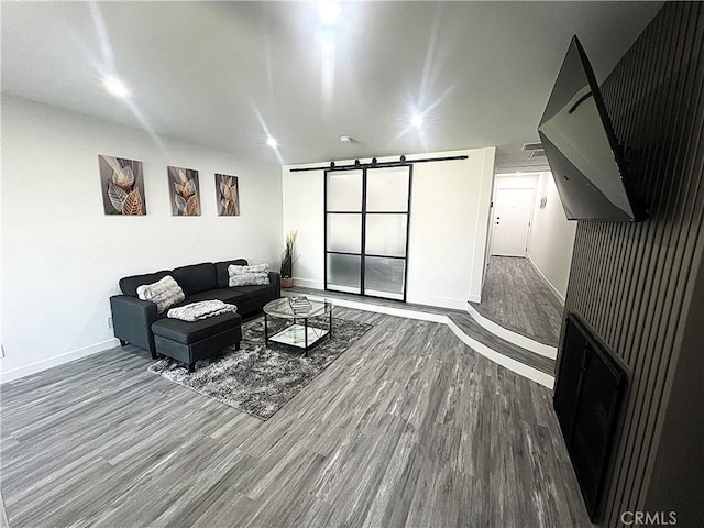 living room featuring a barn door and hardwood / wood-style floors