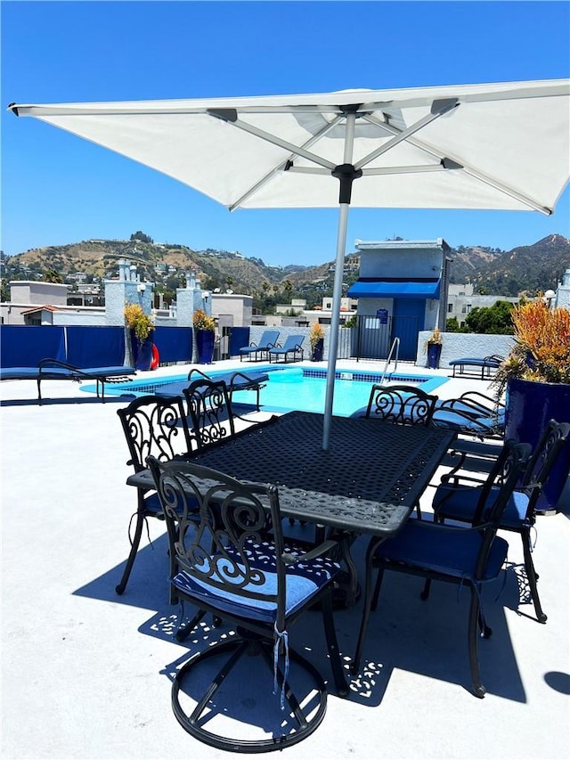 view of patio with a mountain view and a community pool