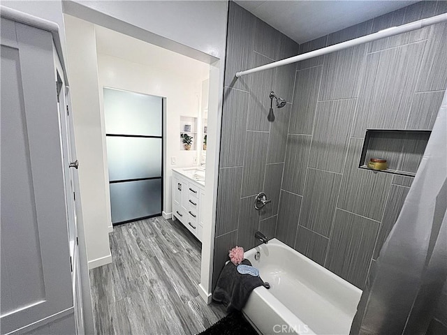 bathroom featuring tiled shower / bath, vanity, and wood-type flooring