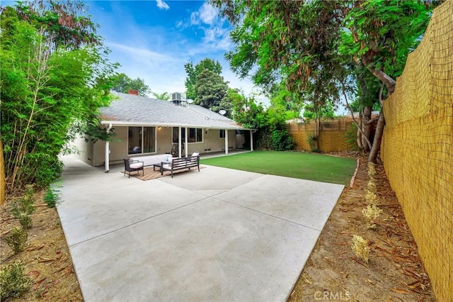 back of property featuring a yard, an outdoor hangout area, and a patio