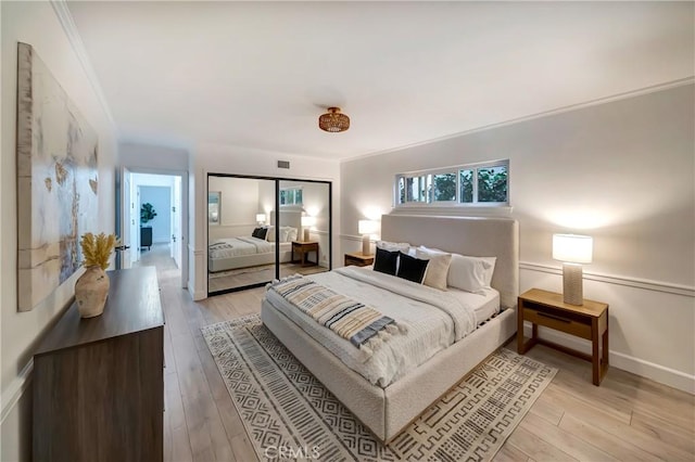 bedroom featuring ornamental molding, light hardwood / wood-style floors, and a closet