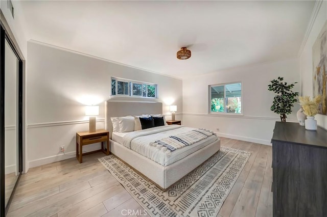 bedroom with crown molding and light hardwood / wood-style floors