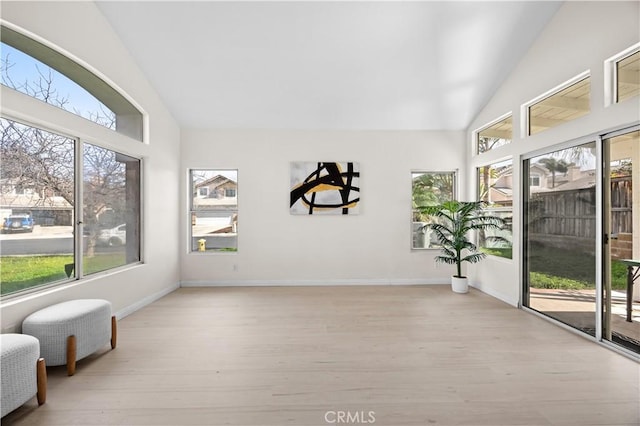 sunroom featuring lofted ceiling and a healthy amount of sunlight