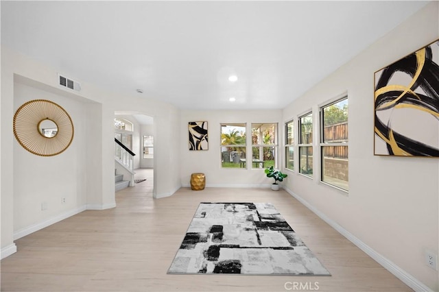 workout area featuring baseboards, visible vents, and light wood-style floors