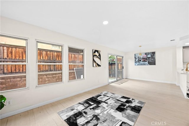 unfurnished living room featuring light wood finished floors, baseboards, and recessed lighting