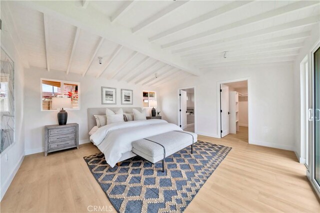 bedroom featuring lofted ceiling with beams, a spacious closet, and hardwood / wood-style floors