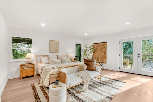 bedroom featuring french doors, light hardwood / wood-style floors, and access to outside