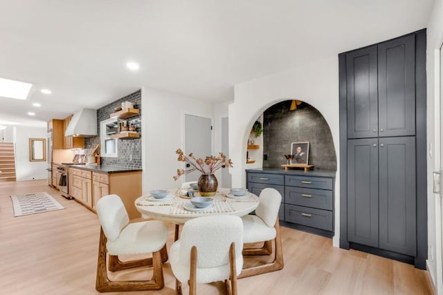 dining area with light hardwood / wood-style flooring and a skylight