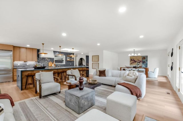 living room with an inviting chandelier and light hardwood / wood-style flooring