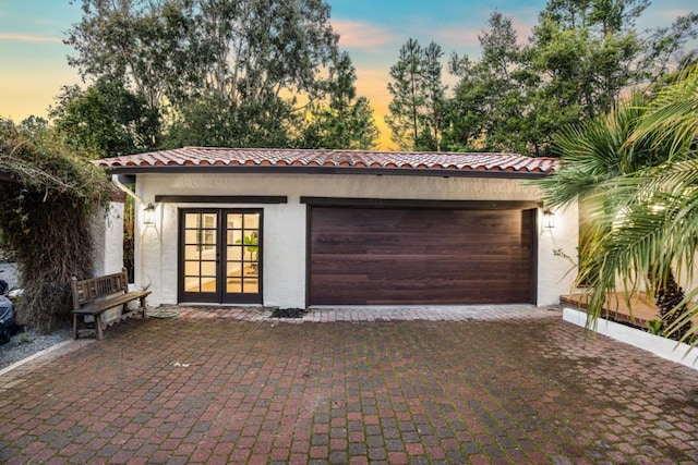 garage at dusk featuring french doors