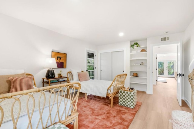 bedroom featuring french doors, hardwood / wood-style floors, and a closet