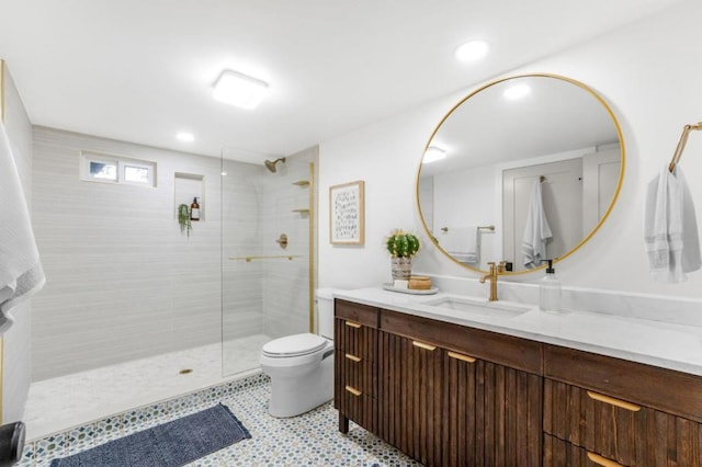 bathroom featuring vanity, toilet, and a tile shower