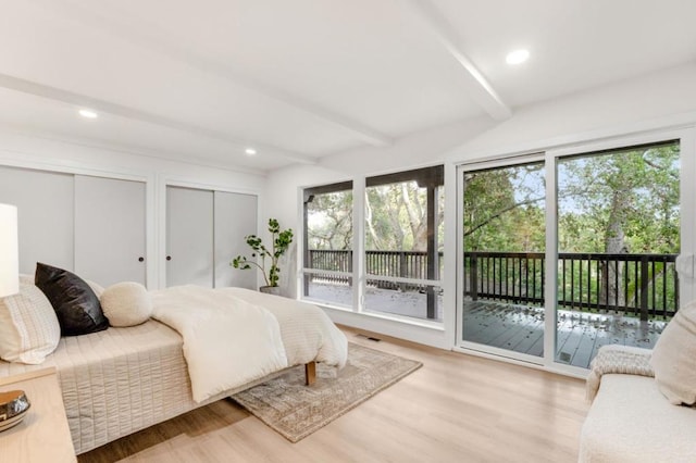 bedroom featuring access to outside, beamed ceiling, multiple closets, and light wood-type flooring