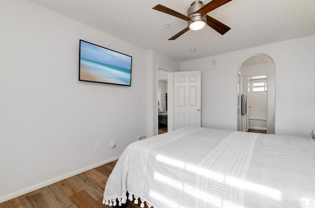 bedroom featuring hardwood / wood-style flooring, connected bathroom, and ceiling fan