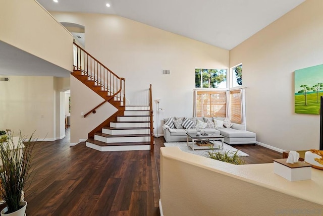 living room with dark hardwood / wood-style flooring and high vaulted ceiling