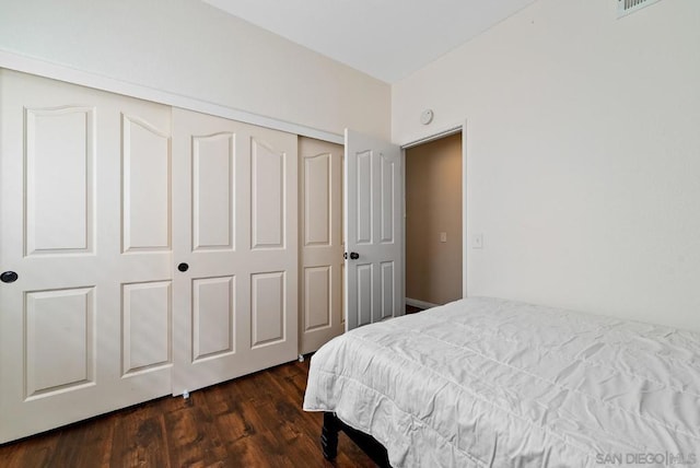 bedroom featuring dark wood-type flooring and a closet