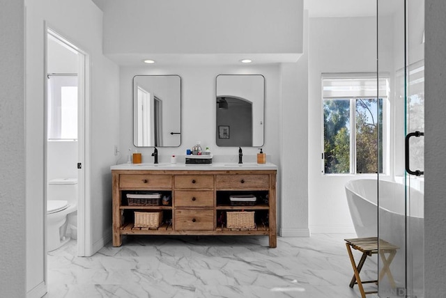 bathroom with a bathing tub, vanity, and toilet