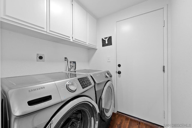 washroom with cabinets, dark hardwood / wood-style flooring, and washing machine and dryer