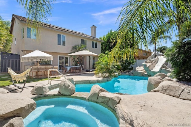 view of pool featuring a bar and a patio