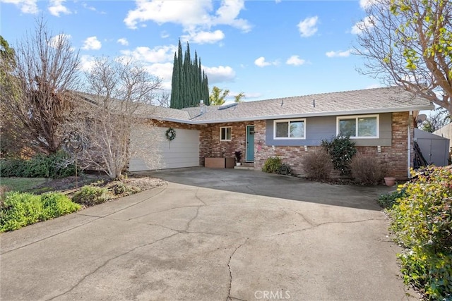 ranch-style house with a garage, brick siding, and driveway