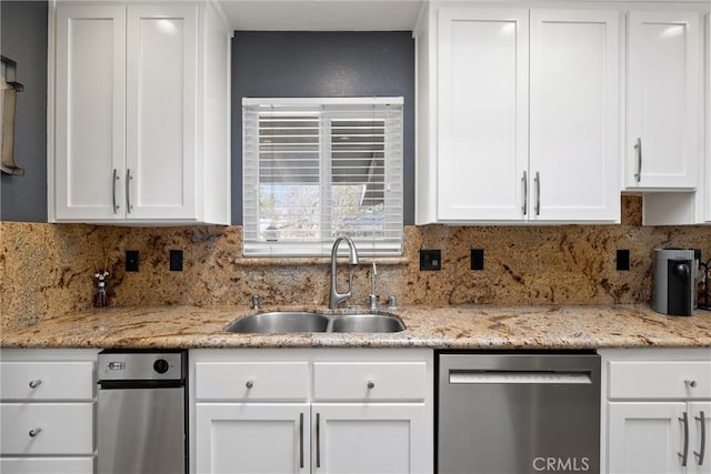 kitchen with a sink, tasteful backsplash, white cabinets, light stone countertops, and dishwasher