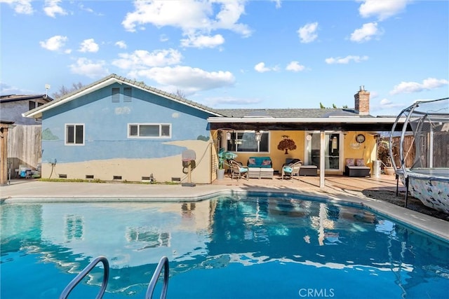 back of house with an outdoor hangout area and a trampoline