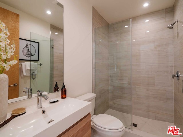 bathroom featuring vanity, a shower with door, and toilet