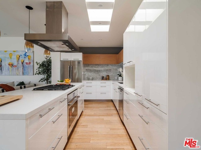 kitchen with white cabinetry, tasteful backsplash, light hardwood / wood-style flooring, appliances with stainless steel finishes, and island exhaust hood