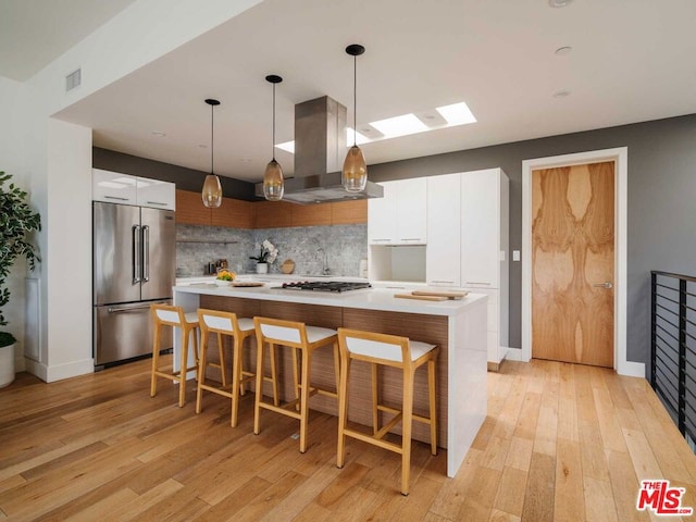 kitchen with white cabinets, island range hood, a center island, and stainless steel built in fridge