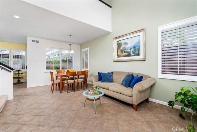 tiled living room with an inviting chandelier