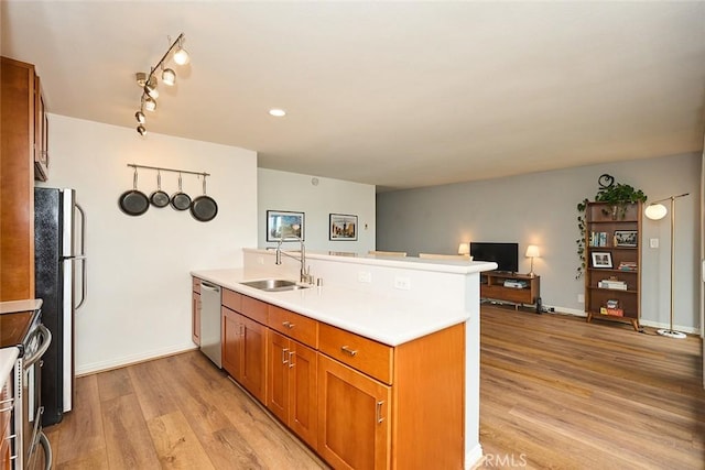 kitchen featuring appliances with stainless steel finishes, light hardwood / wood-style floors, sink, and kitchen peninsula