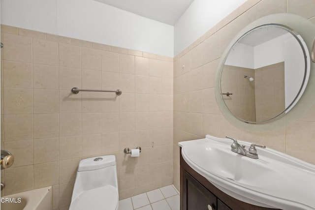 bathroom with toilet, tile patterned flooring, vanity, and tile walls