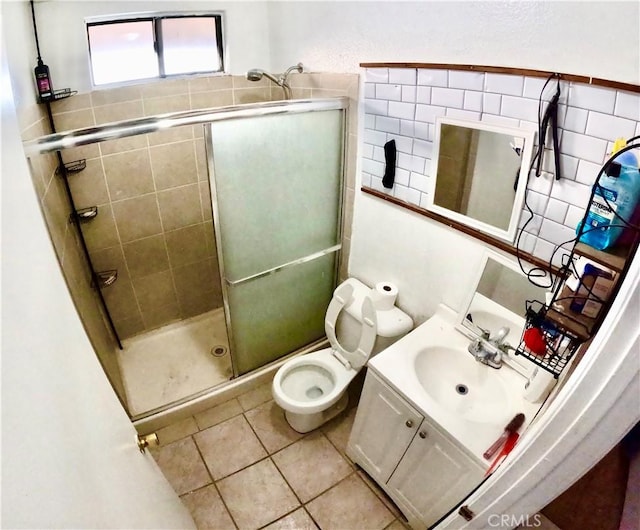 bathroom with vanity, a shower with shower door, tile patterned floors, and toilet