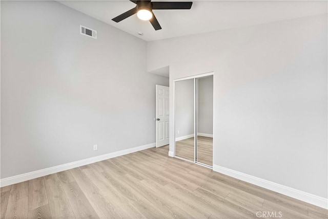 unfurnished bedroom with ceiling fan, lofted ceiling, light hardwood / wood-style floors, and a closet