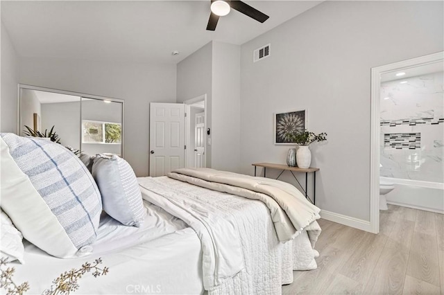 bedroom featuring ensuite bath, light hardwood / wood-style floors, a closet, and ceiling fan