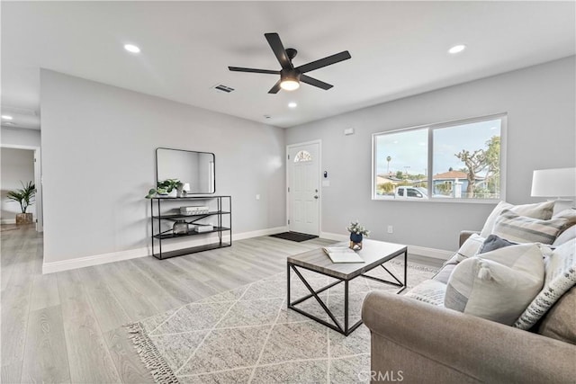 living room with ceiling fan and light hardwood / wood-style flooring